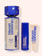 A festive cracker-style gift box from Bloom and Blossom, perfect for the holiday season! The box features a blue and white design with stars and the phrase "All is Calm, The Dream Duo" in bold white lettering. Inside, you'll find two delightful products: a calming sleep spray to help you drift off peacefully and a nourishing lip balm to keep your lips soft and hydrated. This charming gift set is sure to bring joy and relaxation to anyone who receives it.