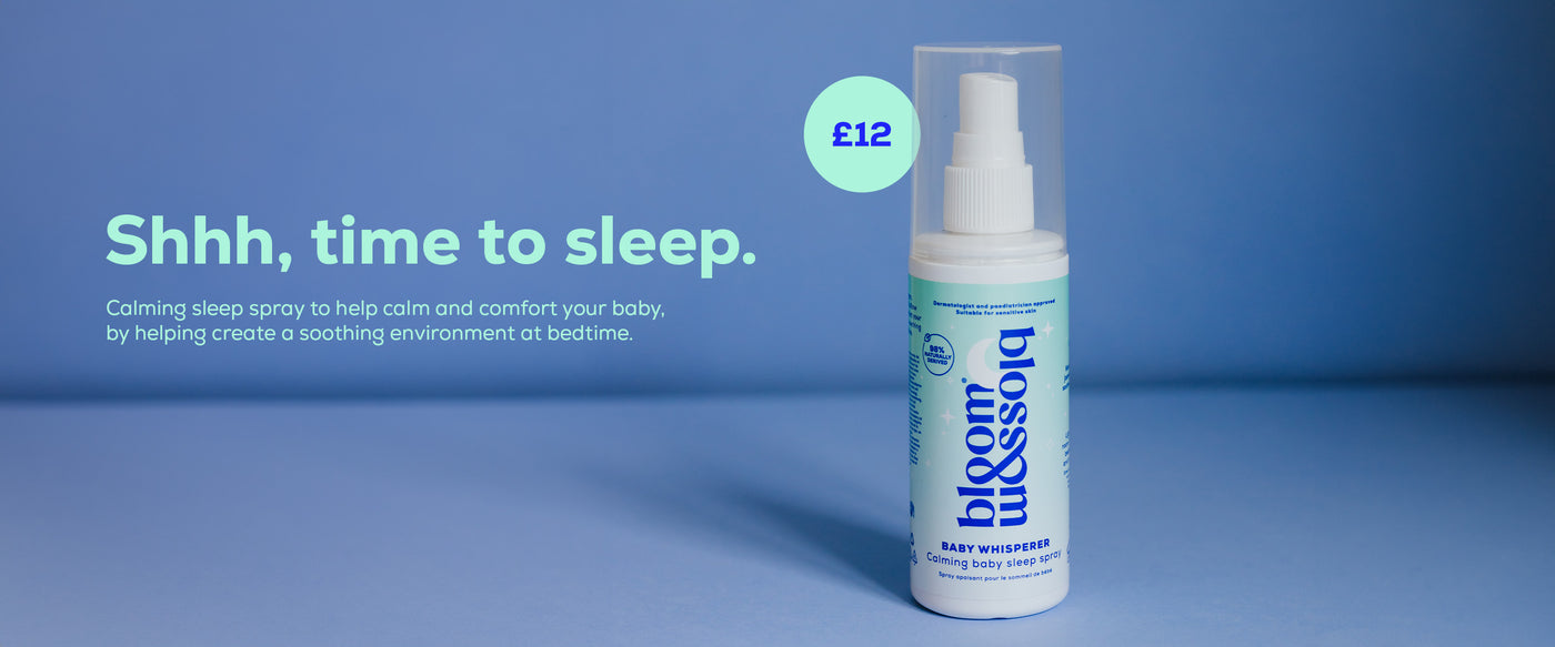 A bottle of Baby Whisperer Calming baby sleep spray placed on a blue background, ready to help soothe and rest your baby at bedtime.