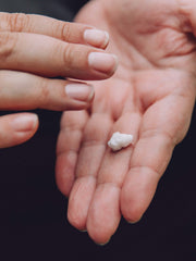 Person rubbing age-defying hand cream into hands.