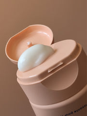 Thick hydrating body cream being squeezed out of tube.