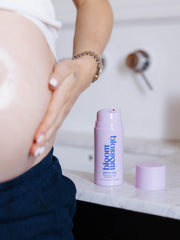 Pregnant woman applying Skin to Skin Bump to baby massage oil to her skin, to soothe and hydrate.