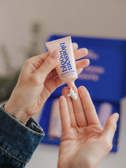 Squeezing a tube of Multi-tasking balm onto hand from pregnancy and new mum gift set.