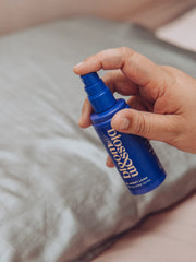 Calming sleep spray being sprayed onto a pillow to help sleep.