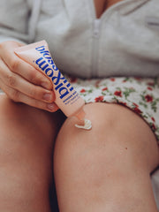 Squeezing out Multi-tasking balm onto dry knees to help nourish and moisturise.